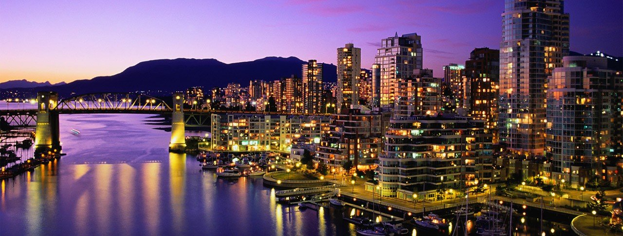 vista de una ciudad en la noche junto a un cuerpo de agua