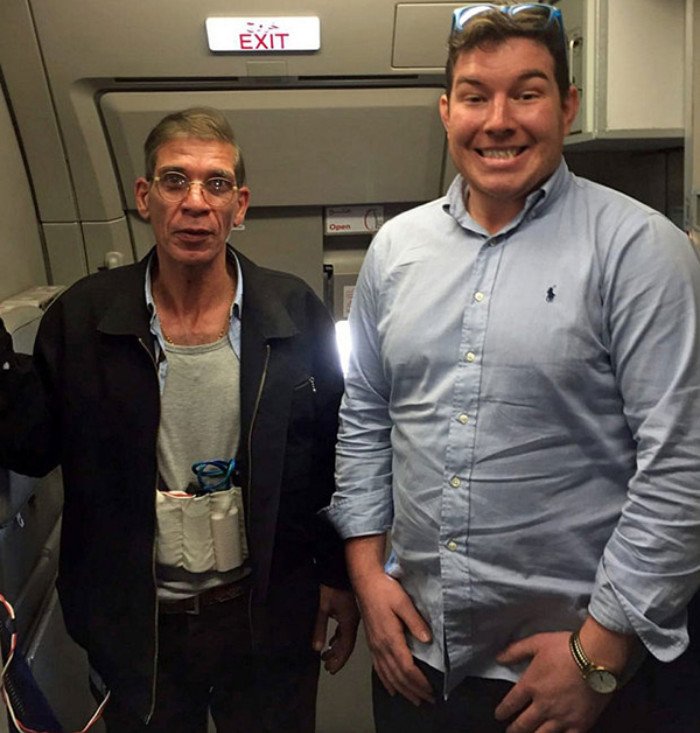 un hombre parado en frente de un grupo de personas sonriendo