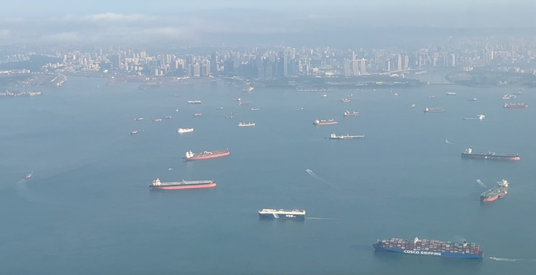 Sobrevolando el Estrecho de Singapur ciudad vista desde arriba de un barco en el agua