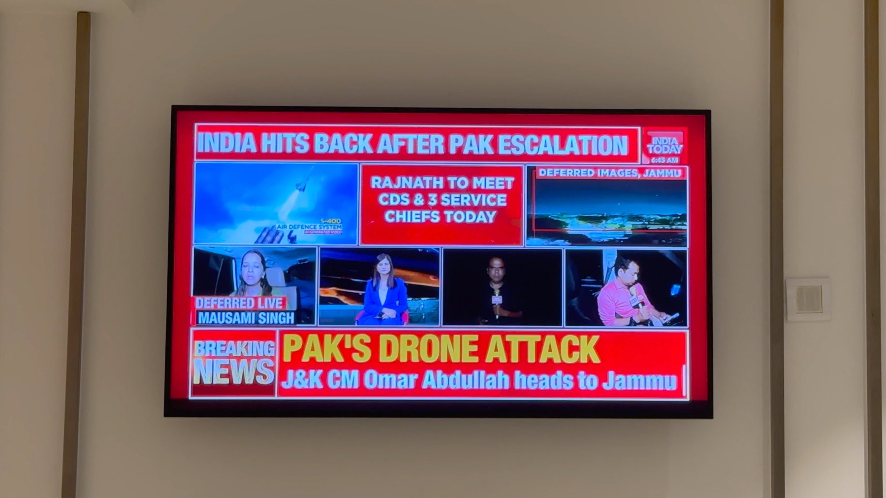 Las noticias reflejando la escalada del conflicto entre India y Pakistán pantalla de video juego en la pared